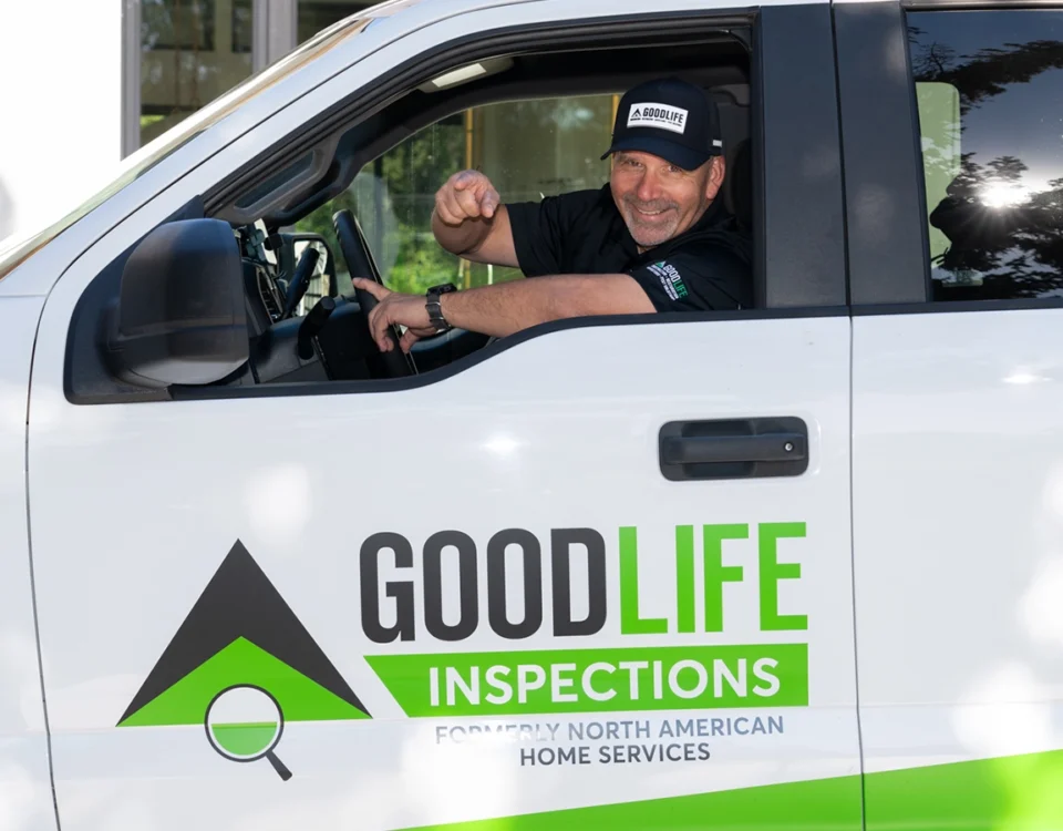 Smiling Good Life Inspections inspector waving from a branded company truck