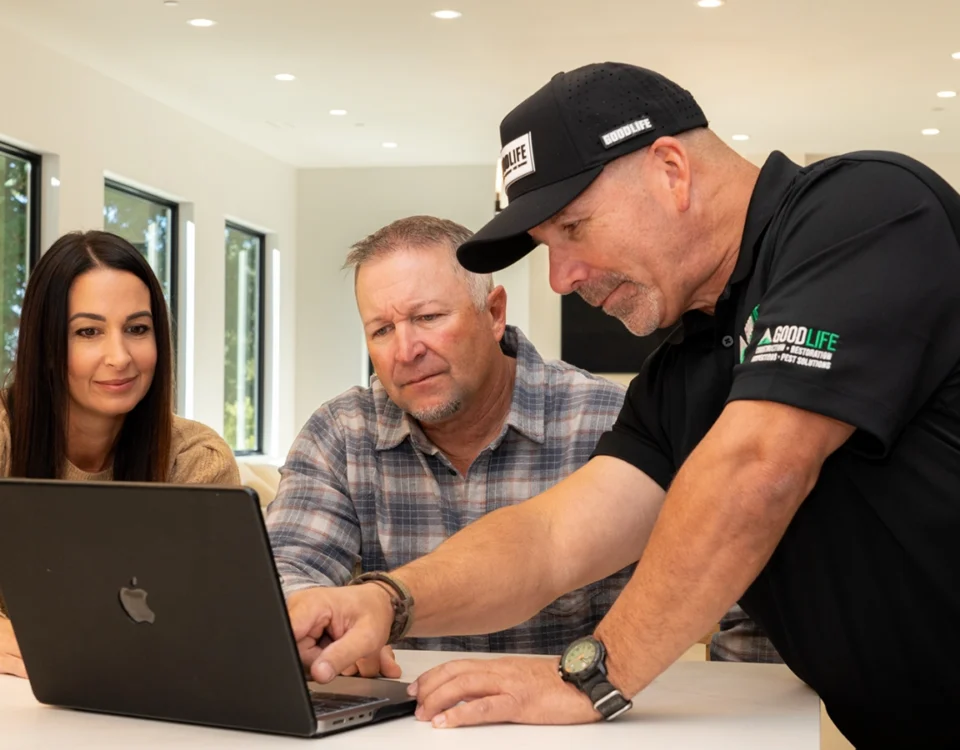 Good Life Inspector technician showing a couple information on a laptop at their kitchen table